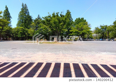 夏日清晨，住宅區公園的景色，露台屋頂的影子投射在公園裡。 140200412