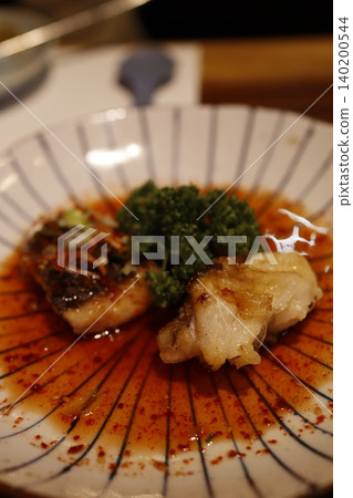 Sizzling Fish Dish with Broccoli and Sauce on Plate Sizzling Fish Dish with Broccoli and Sauce on Plate 140200544