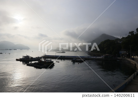 Foggy Harbor at Dawn with Mountain Silhouette Foggy Harbor at Dawn with Mountain Silhouette 140200611