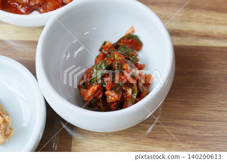 Korean Kimchi in White Bowl on Wooden Surface Korean Kimchi in White Bowl on Wooden Surface 140200613
