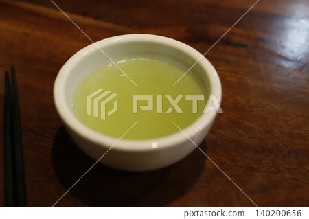 Matcha Tea in White Bowl on Wooden Table Matcha Tea in White Bowl on Wooden Table 140200656