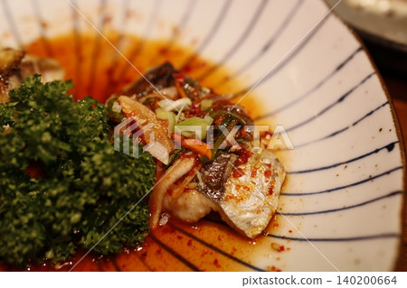 Sizzling Fish Dish with Fresh Greens and Spicy Sauce Sizzling Fish Dish with Fresh Greens and Spicy Sauce 140200664