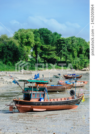 many empty Thai fishing boats lay down on a sea base 140200964