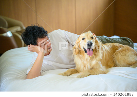 A man lying down with a dog A man lying down with a dog 140201992