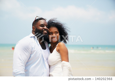 Romantic Black couple enjoying tropical holiday together by the sea Romantic Black couple enjoying tropical holiday together by the sea 140202368