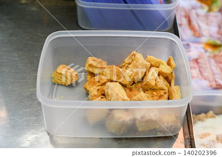 Traditional Chinese crunchy almond puff pastry cookies inside plastic container box at local street food bakery shop counter display in Taipa Macau Traditional Chinese crunchy almond puff pastry cookies inside plastic container box at local street food bakery shop counter display in Taipa Macau 140202396