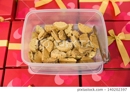 Traditional Chinese almond cookies pastry with carved character inside plastic container box on red gift boxes counter display at bakery shop in Macau 140202397