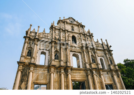 Ancient facade of unesco ruins of st paul built in 1602 historical stone landmark and famous tourist attraction in Macau China during summer day Ancient facade of unesco ruins of st paul built in 1602 historical stone landmark and famous tourist attraction in Macau China during summer day 140202521