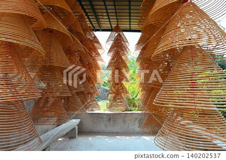 Traditional Chinese spiral incense coils hanging under roof of ancient A-Ma Temple famous historical religious landmark in Macau travel destination China Traditional Chinese spiral incense coils hanging under roof of ancient A-Ma Temple famous historical religious landmark in Macau travel destination China 140202537