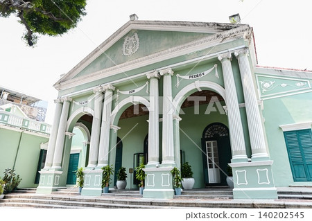 Beautiful green facade of historic unesco Dom Pedro V Theatre building with neoclassical architecture columns during summer day in Macau landmarks Beautiful green facade of historic unesco Dom Pedro V Theatre building with neoclassical architecture columns during summer day in Macau landmarks 140202545