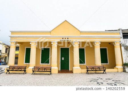 Front view of yellow Portuguese colonial architecture of historic heritage building Coloane Library built in 1911 in Macau China Front view of yellow Portuguese colonial architecture of historic heritage building Coloane Library built in 1911 in Macau China 140202559
