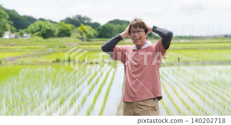 A farmer with his head in his hands. 140202718