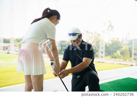 Professional golf coach adjusting posture for female student Professional golf coach adjusting posture for female student 140202736