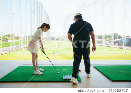 Professional golf coach adjusting posture for female student Professional golf coach adjusting posture for female student 140202737