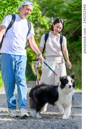 A young couple walking their dog A young couple walking their dog 140202940