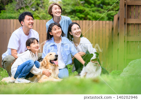 Family and dog relaxing in the garden Family and dog relaxing in the garden 140202946