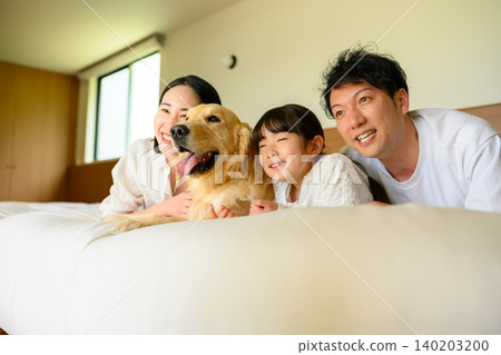 Family and dog relaxing in bed Family and dog relaxing in bed 140203200