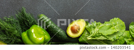 A vibrant assortment of fresh green vegetables is carefully arranged on a dark surface A vibrant assortment of fresh green vegetables is carefully arranged on a dark surface 140203541