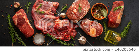Different cuts of beef steak are arranged on a black surface. Fresh herbs, spices, and garlic accompany the meat, ready for cooking or grilling at a kitchen or market, banner Different cuts of beef steak are arranged on a black surface. Fresh herbs, spices, and garlic accompany the meat, ready for cooking or grilling at a kitchen or market, banner 140203546