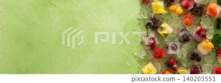 Green background with ice cubes with frozen berries and fruits and mint, banner 140203551