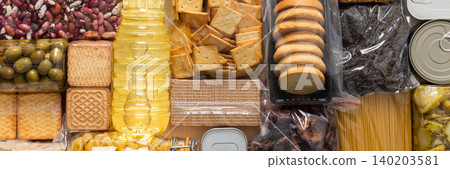 Home food supplies for quarantine and isolation, including canned food, cereals, pasta, and essential staples for survival, survival during military operations, the concept of stay at home, banner Home food supplies for quarantine and isolation, including canned food, cereals, pasta, and essential staples for survival, survival during military operations, the concept of stay at home, banner 140203581