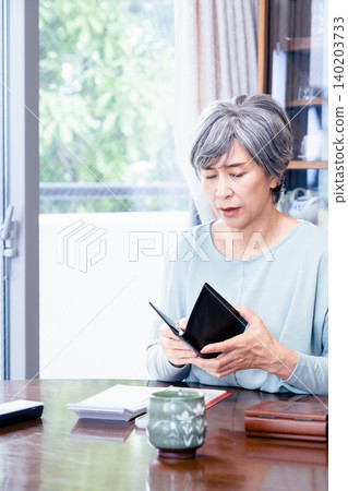 一位拿著筆記本的老婦人。 140203733