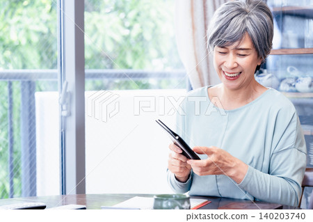A senior woman holding a notebook. 140203740
