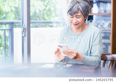 操作智能手機的資深婦女 140203795