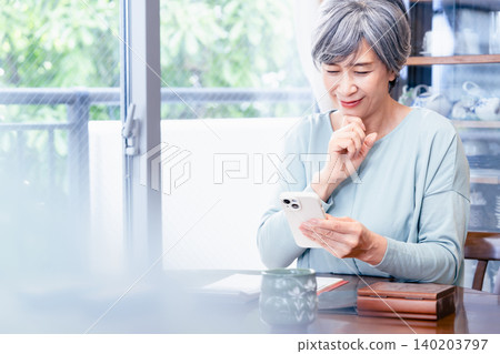 操作智能手機的資深婦女 140203797