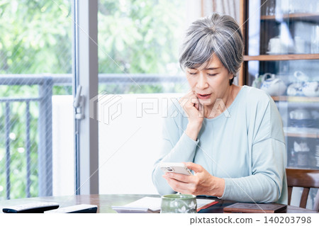Senior woman operating a smartphone 140203798