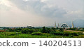 Modern domed mosque with minarets and mountain backdrop 140204513