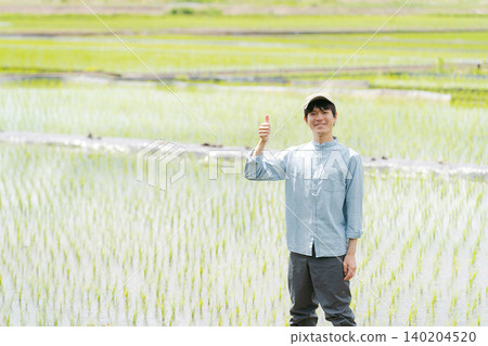 一位年輕的農民豎起了大拇指。 一位年輕的農民豎起了大拇指。 140204520