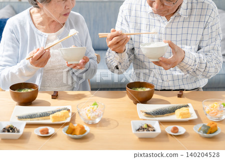 Senior couple eating at hand Senior couple eating at hand 140204528