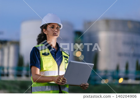 Professional Engineer Woman Proud Confident Working at Refinery plant background twilight evening. 140204906