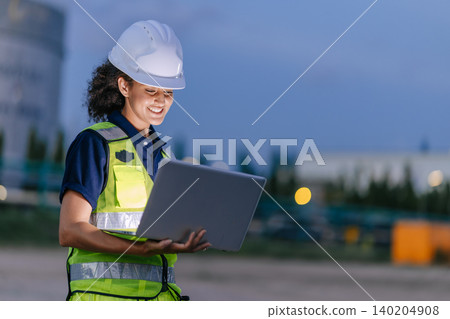Professional Engineer Woman Happy Working at Refinery plant background twilight evening. 140204908