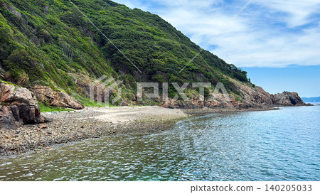 A tranquil coastal landscape of a cove with rocky shores and small beaches. 140205033