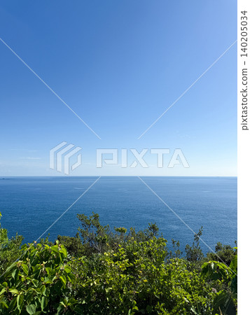 A sea view from a hilltop overlooking the blue sea and clear blue sky. 140205034