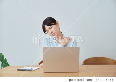 Women experiencing shoulder stiffness while working from home 140205233