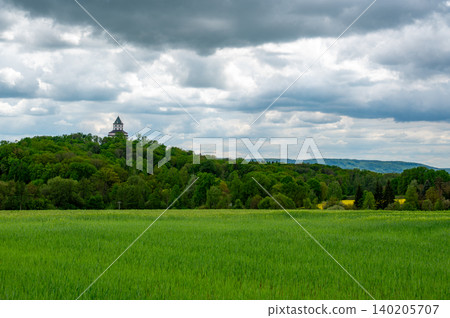 Panoramic view of Cesky Raj landscape in the Czech Republic with Humprecht Castle tower rising above meadows, forests and fields under a dramatic sky before spring rain. Panoramic view of Cesky Raj landscape in the Czech Republic with Humprecht Castle tower rising above meadows, forests and fields under a dramatic sky before spring rain. 140205707