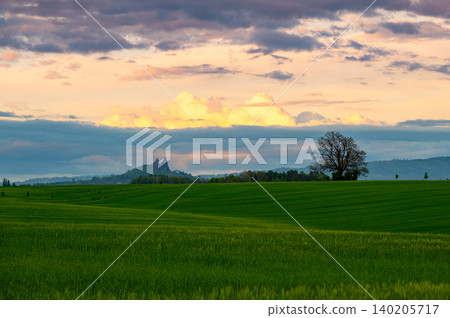 Panoramic view of Cesky Raj in Czech Republic with Trosky Castle ruins on twin basalt rocks. Sunset lights the clouds orange, a popular landmark above rolling countryside. Panoramic view of Cesky Raj in Czech Republic with Trosky Castle ruins on twin basalt rocks. Sunset lights the clouds orange, a popular landmark above rolling countryside. 140205717