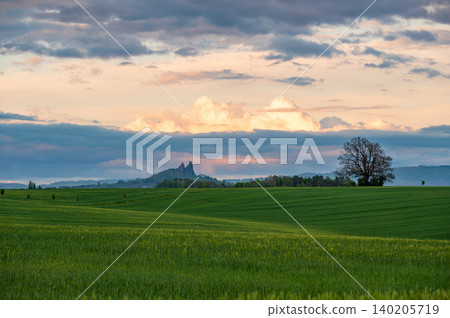 Panoramic view of Cesky Raj in Czech Republic with Trosky Castle ruins on twin basalt rocks. Sunset lights the clouds orange, a popular landmark above rolling countryside. Panoramic view of Cesky Raj in Czech Republic with Trosky Castle ruins on twin basalt rocks. Sunset lights the clouds orange, a popular landmark above rolling countryside. 140205719