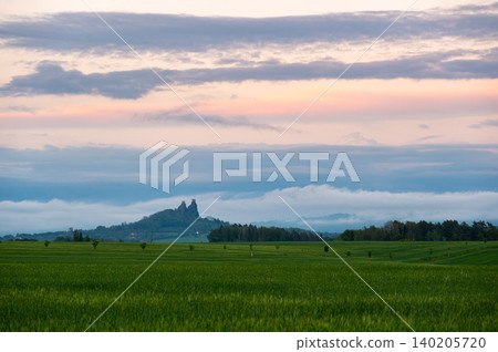Panoramic view of Cesky Raj in Czech Republic with Trosky Castle ruins on twin basalt rocks. Sunset lights the clouds orange, a popular landmark above rolling countryside. Panoramic view of Cesky Raj in Czech Republic with Trosky Castle ruins on twin basalt rocks. Sunset lights the clouds orange, a popular landmark above rolling countryside. 140205720