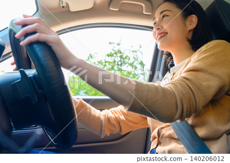 A woman driving with a smile A woman driving with a smile 140206012