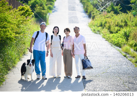 People walking their dogs up a hill People walking their dogs up a hill 140206013