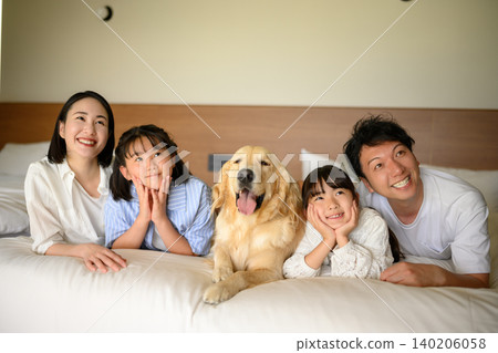 Family and dog relaxing in bed Family and dog relaxing in bed 140206058