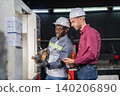 Collaborative equipment setup manufacturing facility instructional interaction industrial environment close-up view workplace safety 140206890
