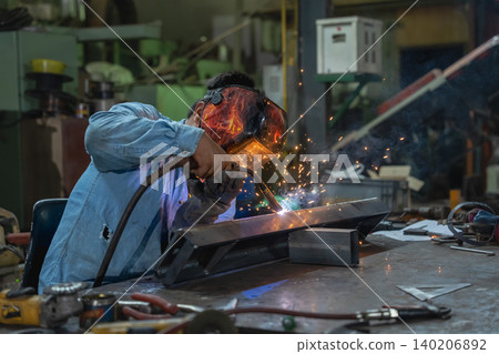 Welding action in workshop metal fabrication scene industrial environment close-up view skilled craftsmanship 140206892
