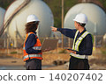 Industrial safety meeting gas storage facility photography outdoor close-up collaboration and teamwork 140207402