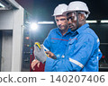 Industrial workers collaborating on equipment maintenance in factory technical inspection indoor professional setting 140207406