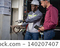 Industrial collaboration engineers discuss project in manufacturing facility workshop teamwork close-up professionalism 140207407
